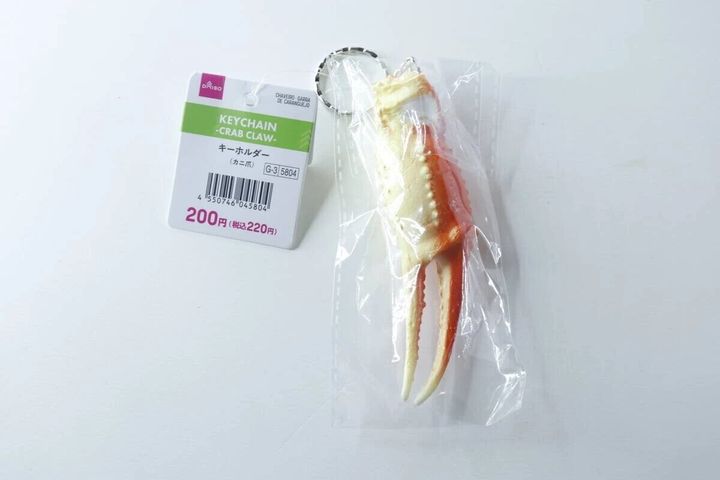 ダイソーのタグが付いたカニ爪キーホルダーが袋に入っている
