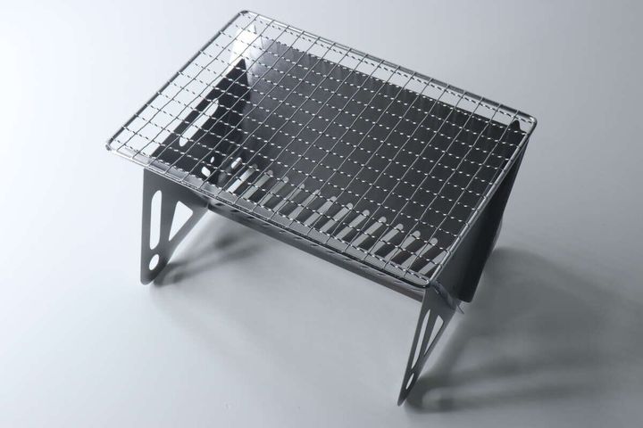 組み立てられたステンレス製BBQコンロの上に網がセットされている。