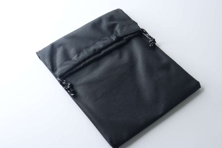 黒い巾着型の収納袋がたたまれて置かれている。