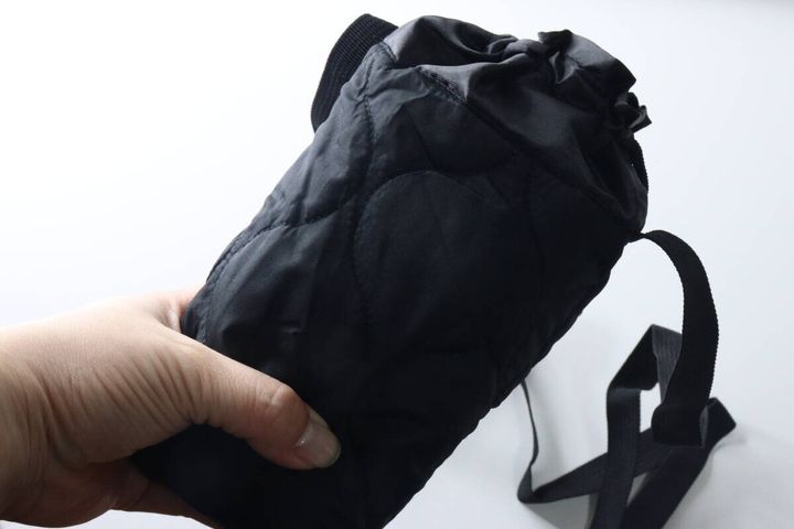 手が600mlのペットボトルが入ったボトルホルダーを持っている