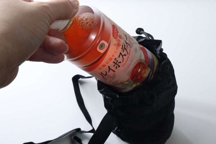 手が600mlのペットボトルをボトルホルダーに入れようとしている