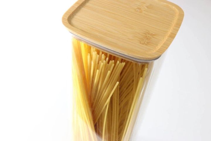 透明な保存容器にスパゲッティが立てて入れられ、竹製の蓋が閉まっている