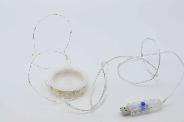 ワイヤーライトが巻かれた状態と、USB給電部分が白い背景に置かれている