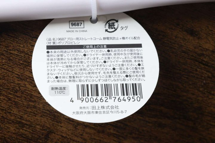 白いブロー用ストレートコームの商品タグ裏面、注意書きとバーコード