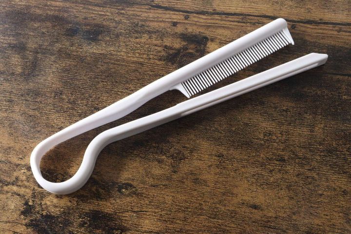 白いブロー用ストレートコームを閉じた状態で木目調のテーブルに置いた写真