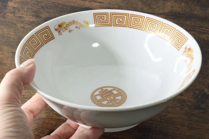 女性の手で持たれた雷門龍柄の本格的なラーメン丼
