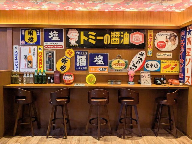 昭和レトロな看板が並ぶ横丁のバーカウンター