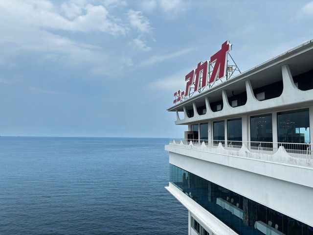 海を背景に「ニューアカオ」の赤いロゴを掲げたホテルの外観