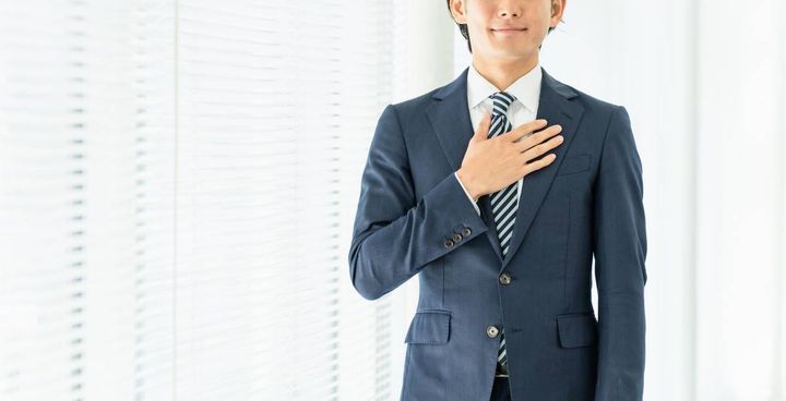 胸に手を当てる人