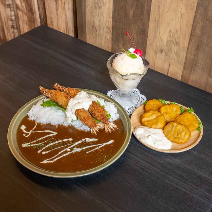 エビフライカレーとチキンナゲット、アイスが並ぶハーベストバージのテーブル