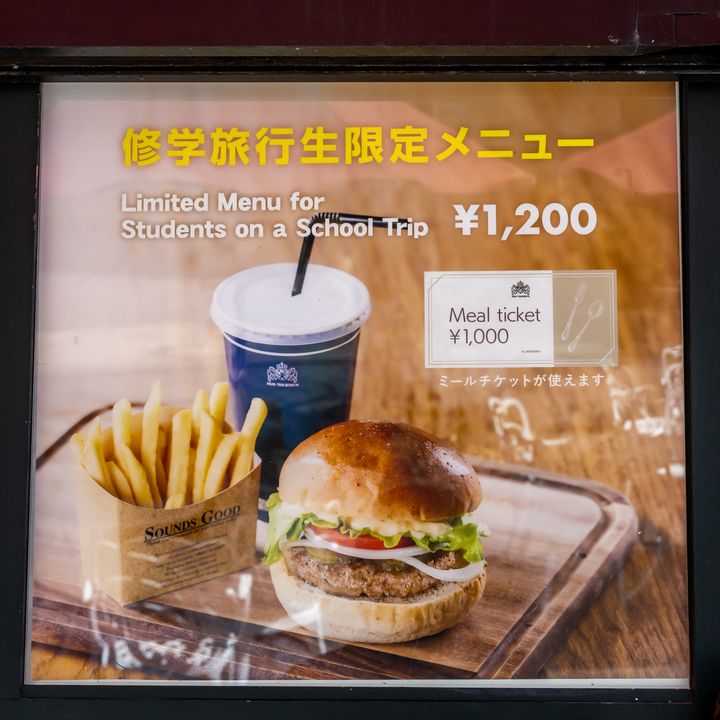 バーガーとポテト、ドリンクがセットになった修学旅行生限定メニューの看板