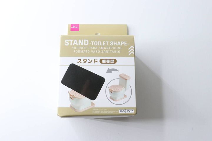 白い背景に置かれた、ダイソーの便器型スマホスタンドのパッケージ