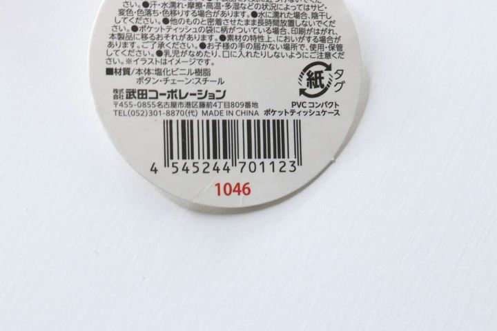 ポケットティッシュケースの商品タグの裏面。JANコードや素材、注意書きが記載されている