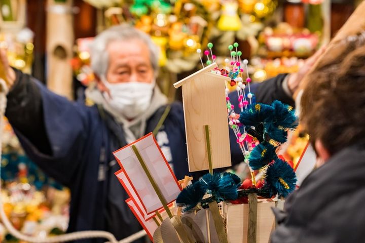酉の市の縁起熊手の屋台 法被を着た男性 酉の市 熊手の買い方