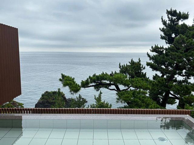 松の木越しに広がる露天風呂からの海の眺め