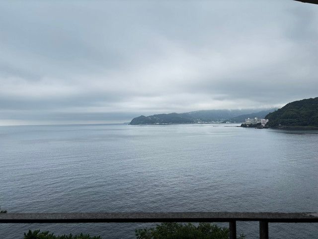 手すり越しに広がる熱海の海岸線の眺め