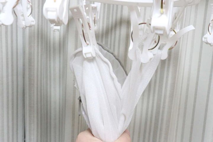 ピンチハンガーから洗濯ネットを引っ張って取り込んでいる手元