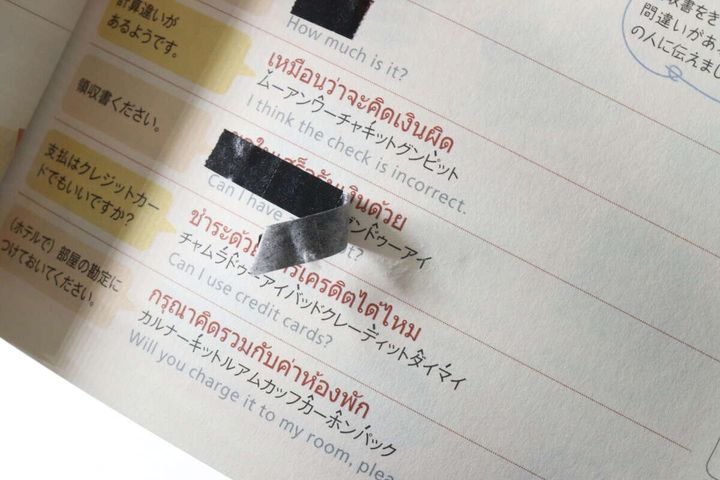 語学参考書に貼られた黒いマスキングテープが剥がれかけている