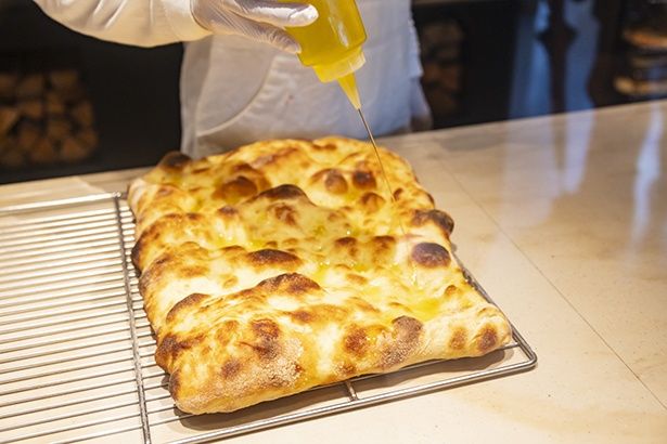 直焼きフォカッチャは、焼き上がりにオリーブオイルをたっぷりかけて仕上げられる