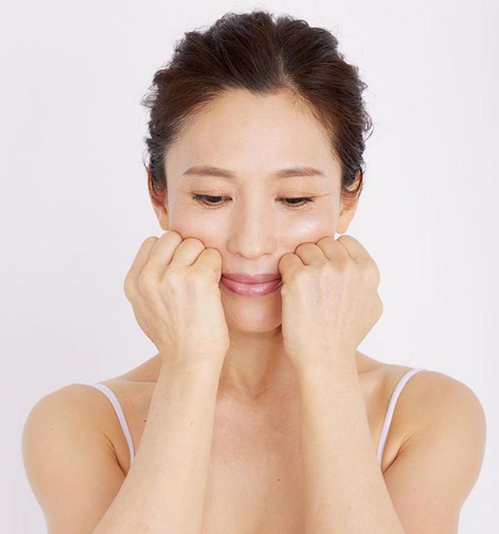両手の握りこぶしを、小鼻のわきに小指が当たるようにおきます。わきはキュッと締めます