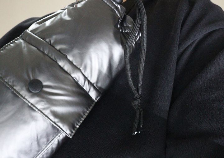 黒い服を着た人がボトルホルダーを斜め掛けしている上半身。