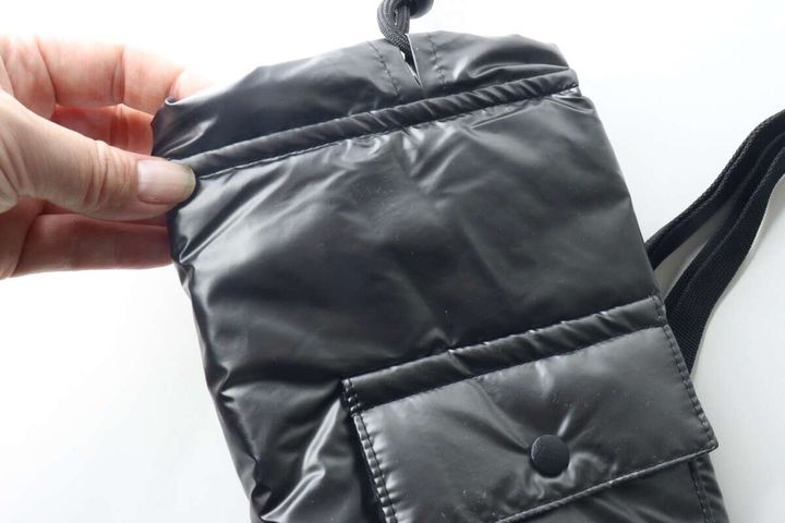 手がボトルホルダーの口元を広げ、中わたの厚みを示している。