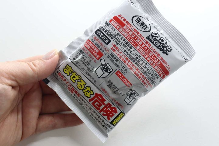 個包装された「シュワッと洗たく槽クリーナー」を持つ手
