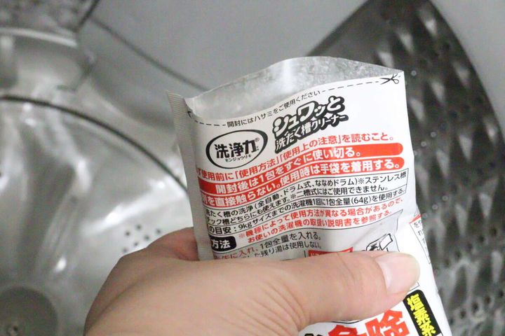 洗濯槽に「シュワッと洗たく槽クリーナー」を投入する手