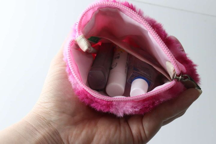 ピンクのヒョウ柄ポーチにリップや目薬などの小物を収納