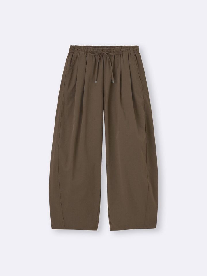 カーキ色のバレルシルエットアンクルパンツ。ウエストゴムと紐付き。