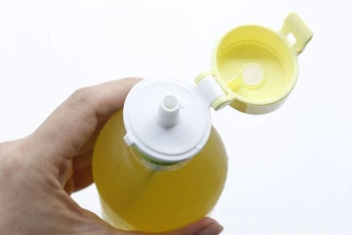 手に持ったペットボトルに装着された黄色いポムポムプリンのキャップ