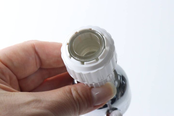 シャワーヘッドの蛇口取り付け口を手に持ち、内側を見せている
