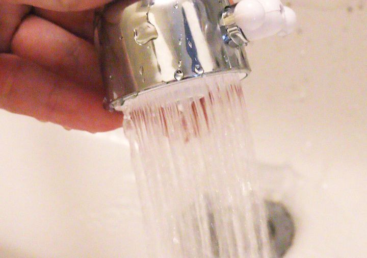 シャワーヘッドからシャワー状の水が勢いよく流れ出ている