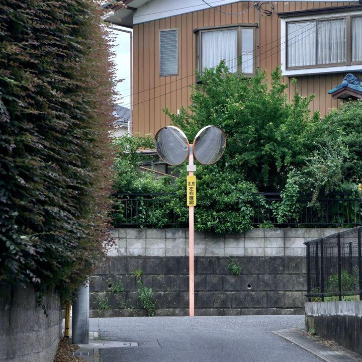 住宅街のT字路に設置された、左右を映す2枚のカーブミラー