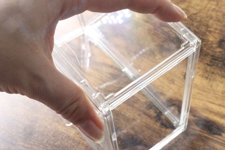 女性の手がケースを積み重ねようとしている