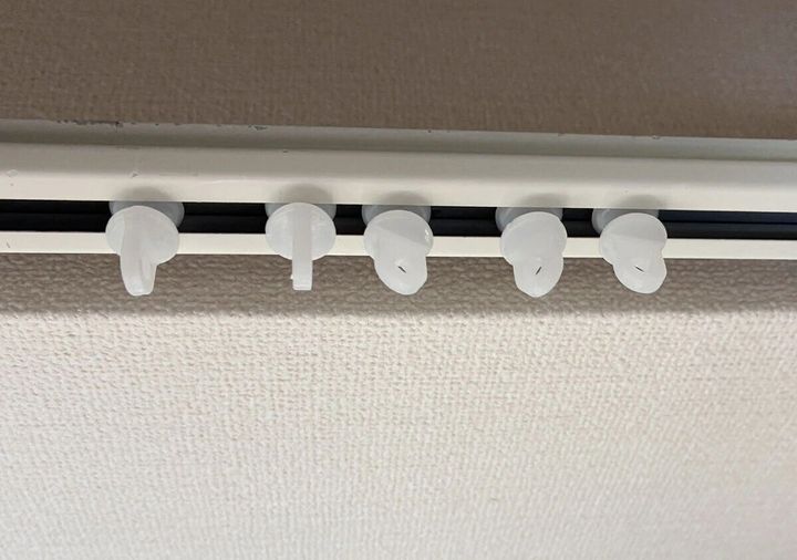 白いカーテンレールにレールランナーが5つ取り付けられている