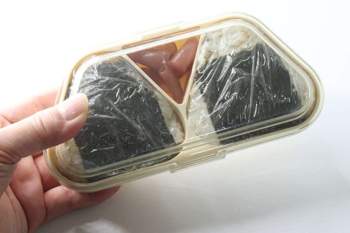完成したおにぎり2個が弁当箱に収まりフタが閉まっている