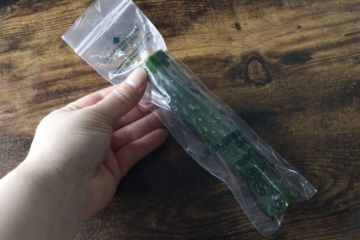 女性の手が一本漬け袋に入ったきゅうりを持っている