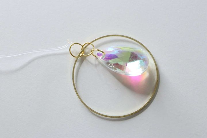 大きな虹色のビーズと金属フープが丸カンで繋がった状態