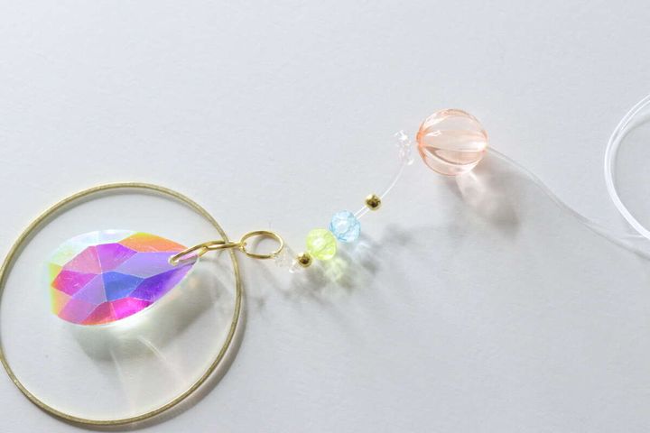 テグスに小さなビーズを通しているサンキャッチャーの制作途中