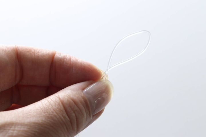 テグスを結んで小さな輪を作っている指先のアップ
