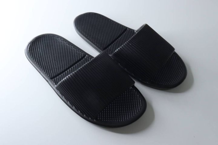 白い背景に並べられたダイソーの黒いサンダル2足