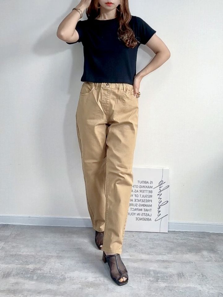 黒いTシャツとベージュのKIDSストレッチストレートパンツSTを着用した女性の全身コーデ
