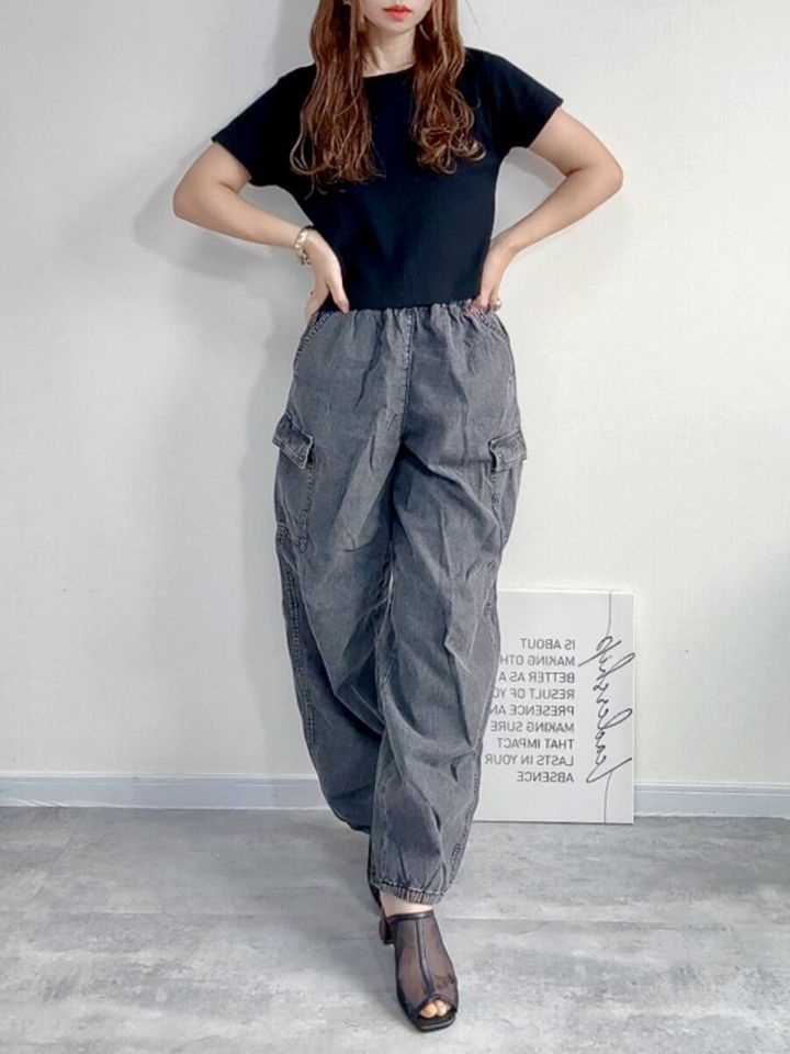 黒いTシャツとグレーのGIRLSライトデニムカーゴバレルレッグパンツJRを着用した女性の全身コーデ