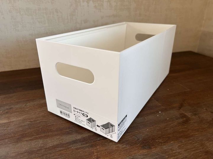 白い伸縮式の整理ボックスが木目の床に置かれ商品ラベルが見える