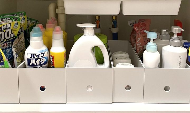 洗面台下の収納に白いファイルボックスが並び洗剤が収納されている