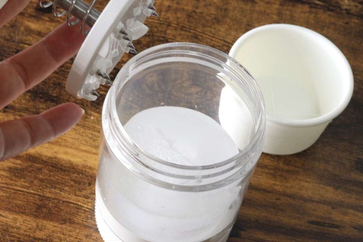 かき氷機本体に付属の製氷カップで作った氷を入れる様子