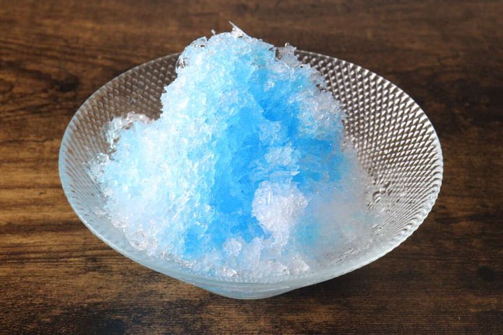 透明なガラスの器に盛られたブルーハワイのかき氷