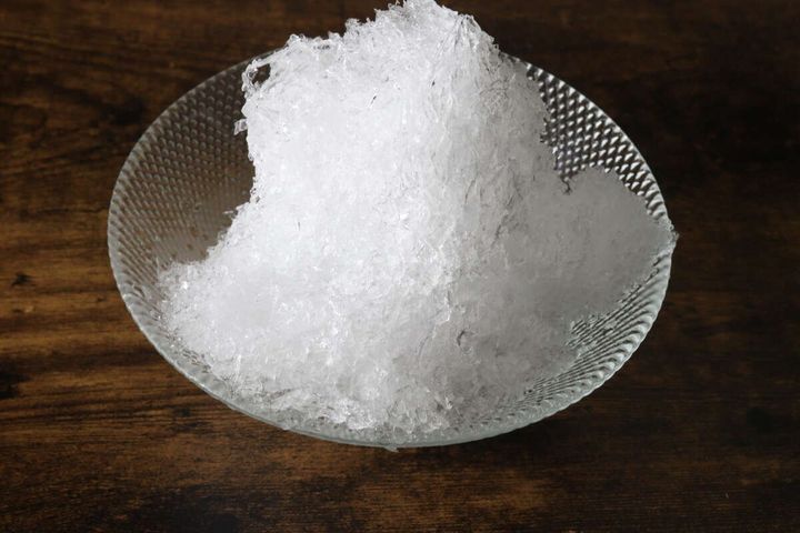 透明なガラスの器に盛られた粒感のある白いかき氷