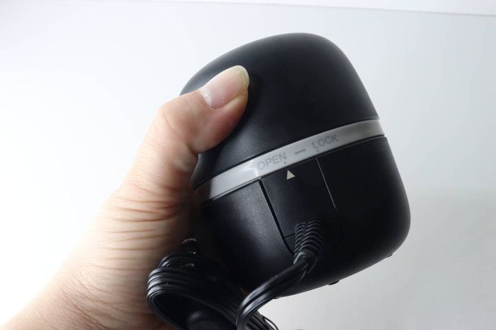 女性の手がマモルーム本体を握りOPEN/LOCK表示が見える